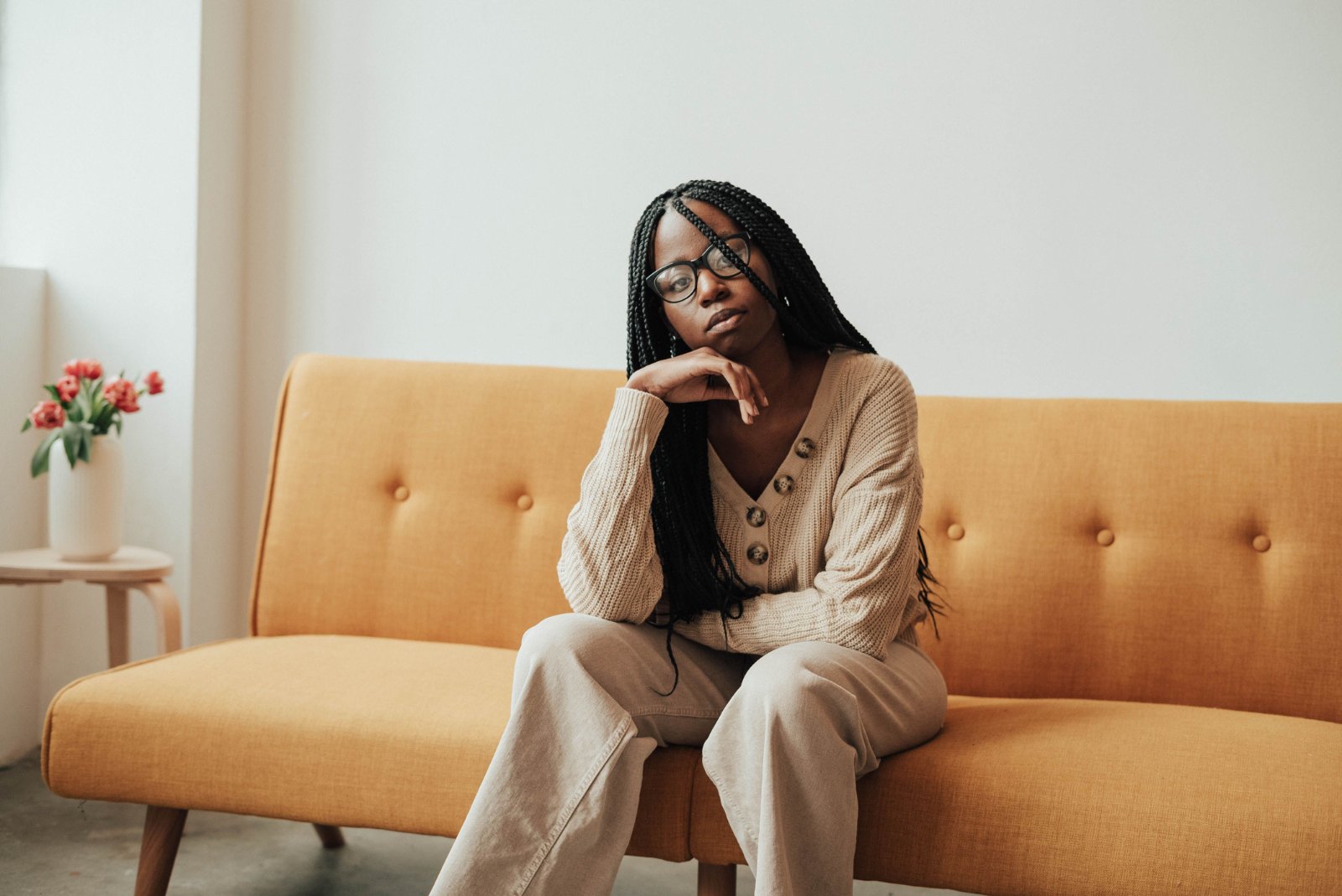 A Black woman resting peacefully in a sunlit bedroom.