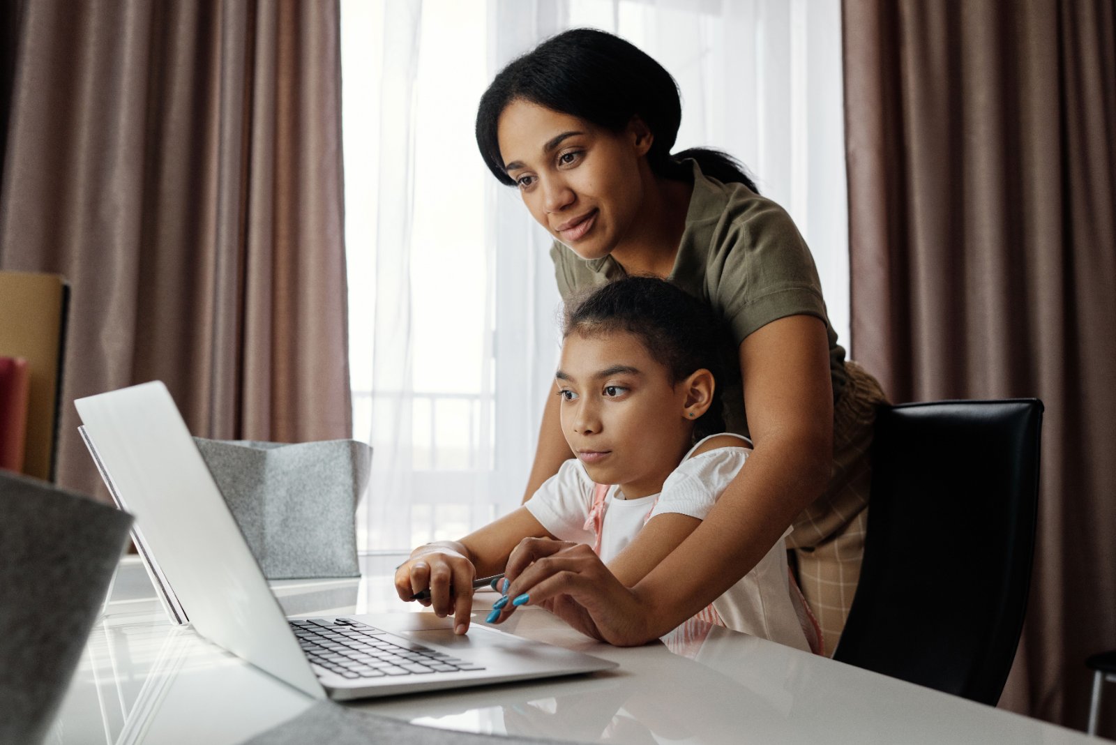 Black schoolgirl completing an assignment with a classmate.