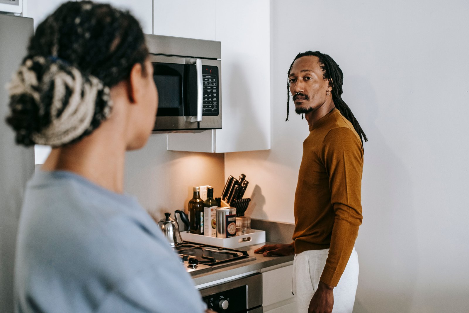 A Black woman having a serious but calm conversation with her partner at home.