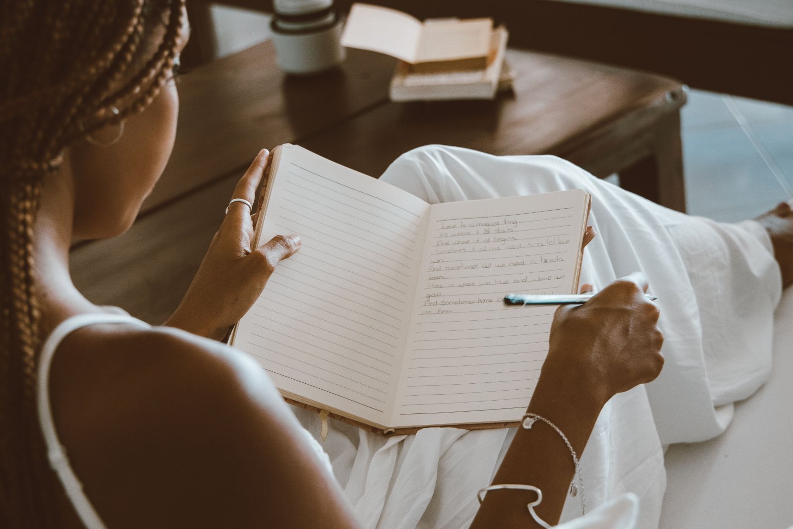 Black woman preparing questions in a notebook before a therapy consultation.