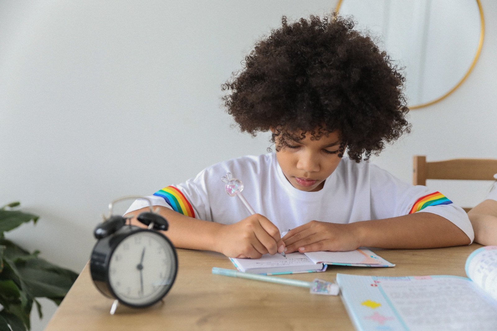 Black mother supporting her daughter during a study session at home.