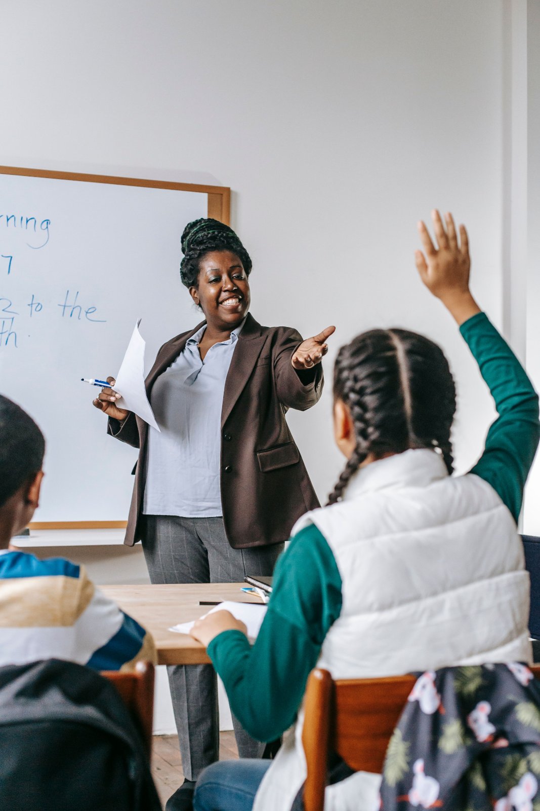 Black mother and daughter reviewing school documents at a table.
